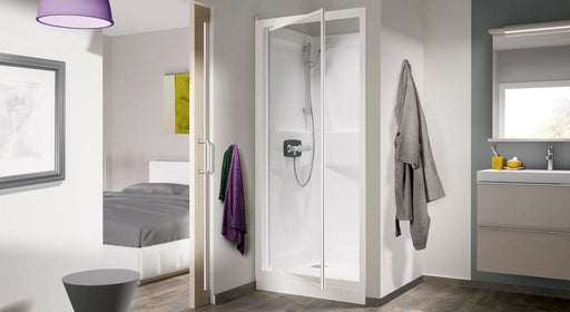 Cabina de ducha empotrable Kinedo Kineprime con puerta abatible de cristal, instalada en un hueco del baño